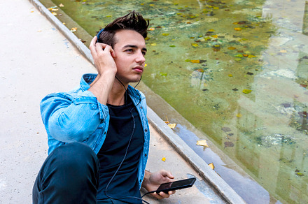 Man listening to music by a pond., a Person Photo by RF Images