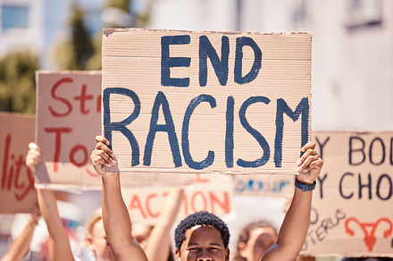 Protest, racism poster and walking people for human rights, black lives matter and inequality movement on city street in USA. Angry crowd with sign for freedom, justice and change in government, a Photo by Peopleimages.com