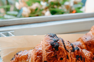 closeup of a chocolate croissant by a window, a Photo by Nito