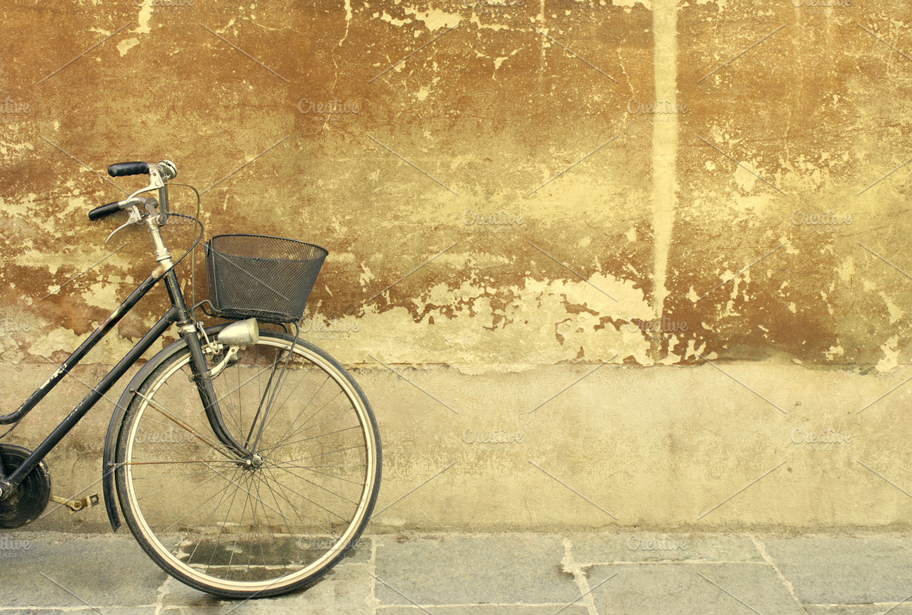 Vintage bicycle containing bicycle, wall, and parking