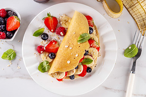 Tasty stuffed oatmeal banana pancake with fresh fruits and berri, a Food & Drink Photo by Rimma