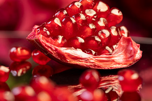 peeled ripe red pomegranate with juicy grains, reflection of a grenade in glass, a Photo by rsoollAI