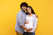 Satisfied young indian man hugging pregnant wife and touching belly, smiling to, a Photo by Prostock-Studio (Thumbnail 2 of 2)