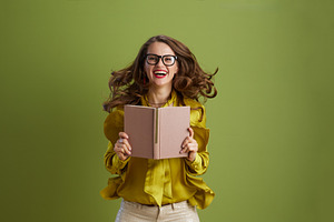 smiling healthy woman in green blouse and glasses on green, a Person Photo by Alliance Images