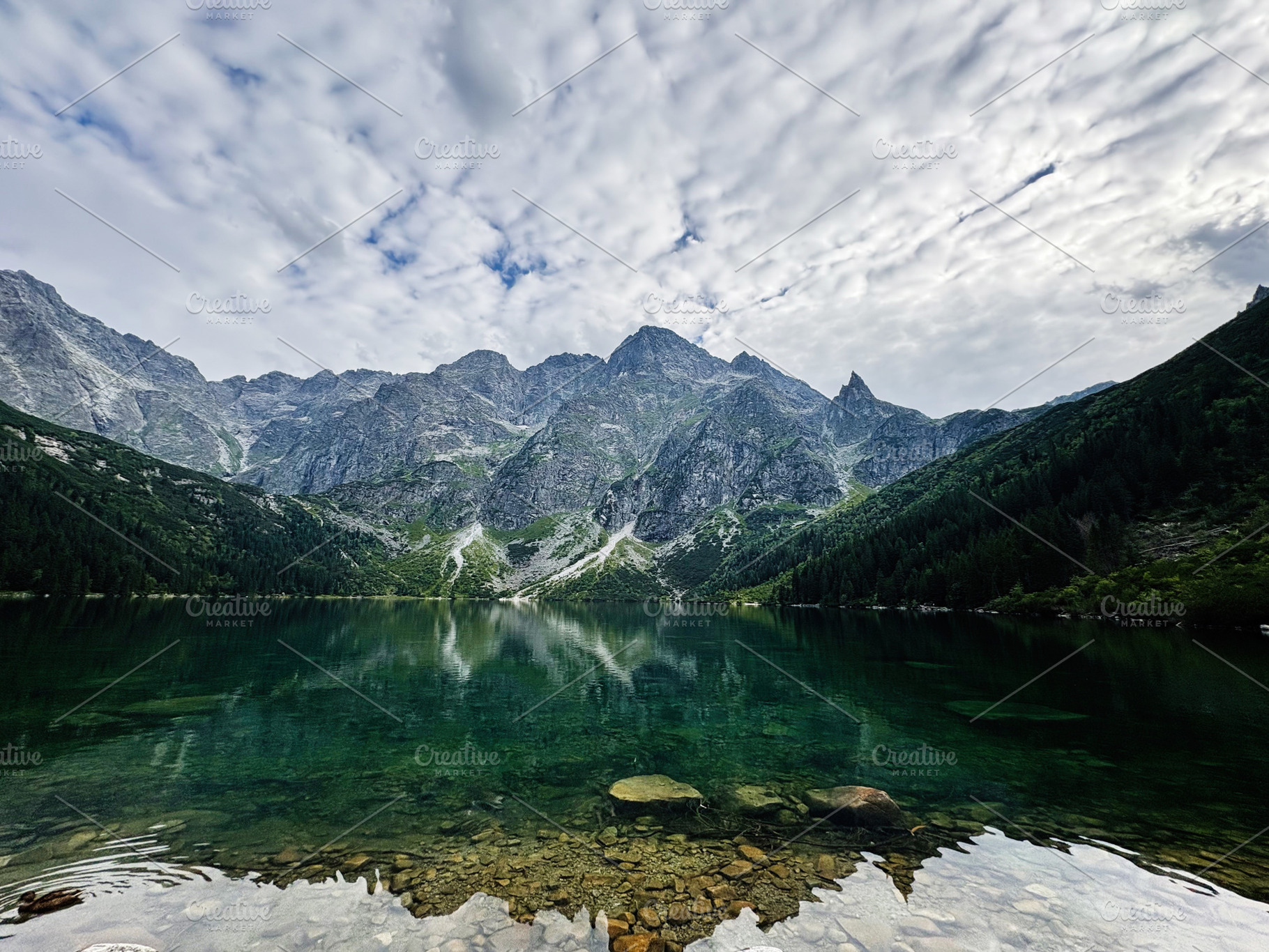 Tranquil alpine lake surrounded by jagged mountains in Zakopane Poland with cle, a Nature Photo by AS photostudio