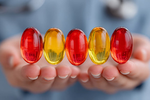 Colorful soft gel capsules held in hands by a healthcare professional, a Health & Medical Photo by AS photostudio