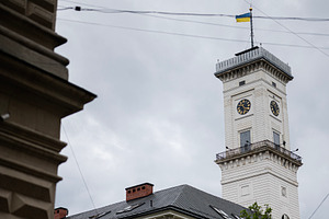 Clock tower with national flag on a cloudy day in Lviv, Ukraine., a Photo by AS photostudio