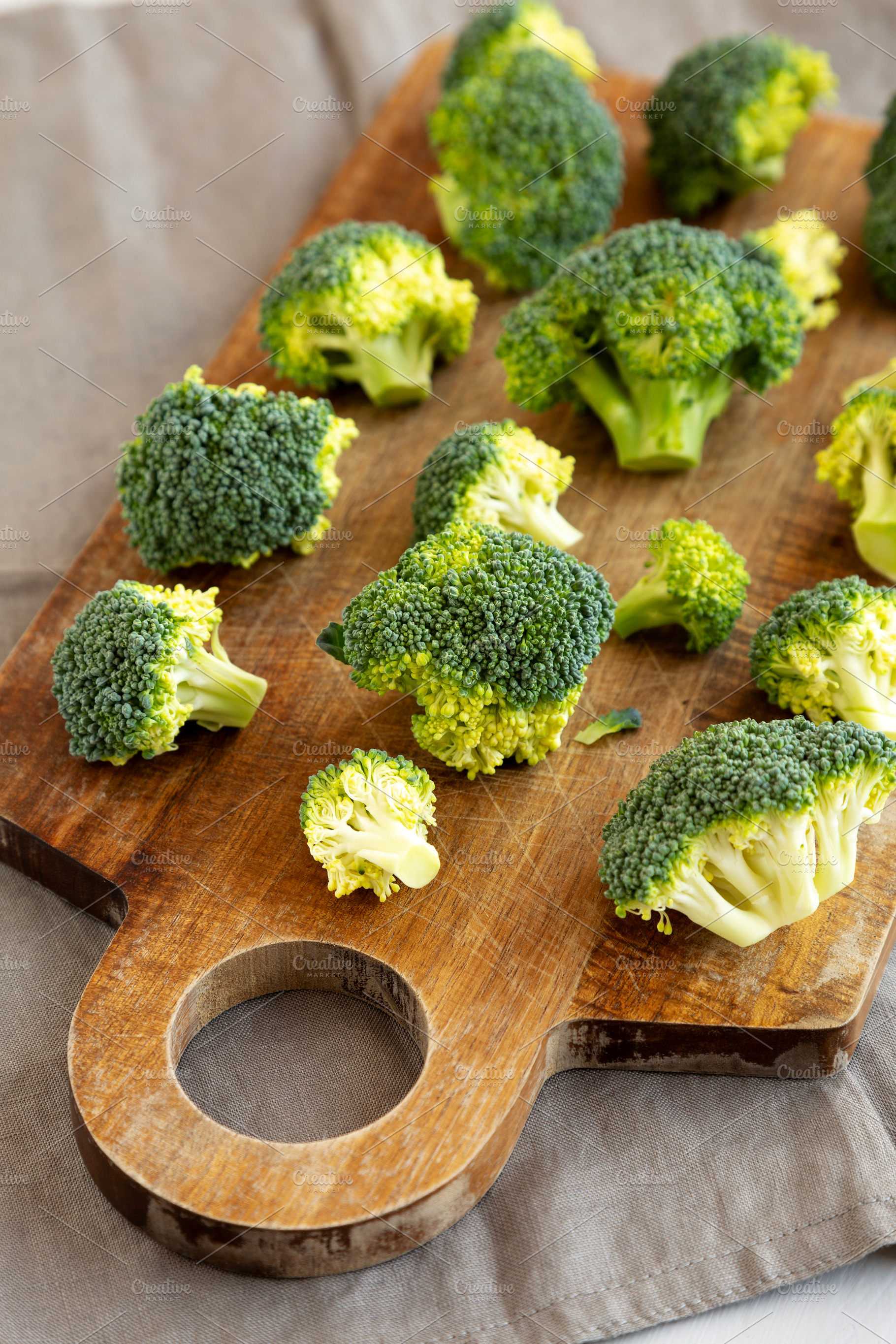 Raw Organic Green Broccoli on a Wooden Board, side view., a Food & Drink Photo by LiudmylaChuhunova