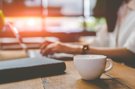 Close up of coffee cup with businesswoman working at outdoors of, a Food & Drink Photo by Ministocker