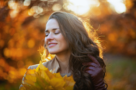 relaxed young woman in brown coat and yellow hat, a Person Photo by Alliance Images