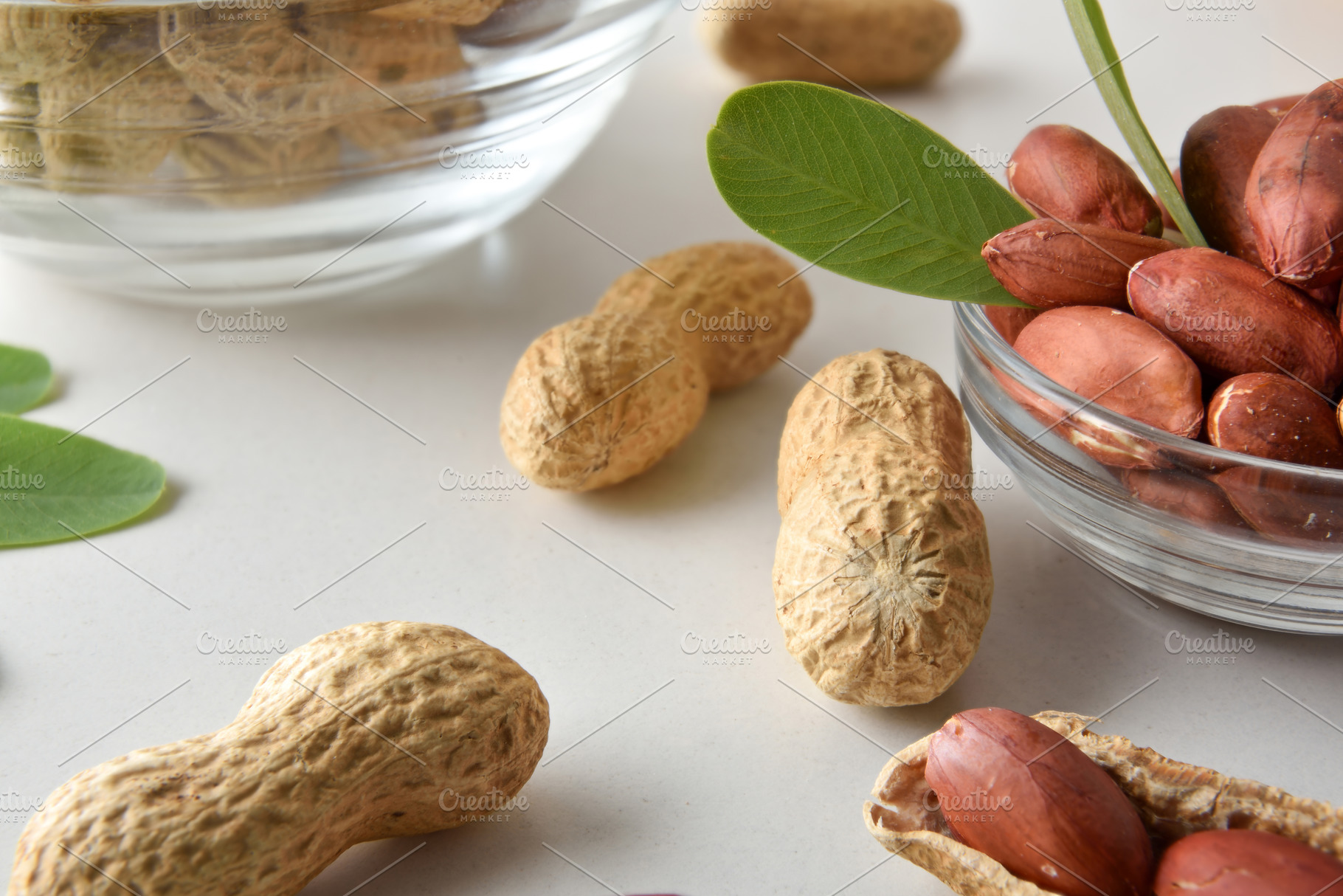 Detail of peeled peanuts in glass bowl on a white table, a Food & Drink Photo by Davizro's Market