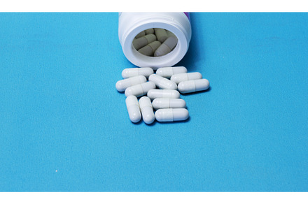 Pills spilled out of white bottle on, a Health & Medical Photo by shahin.mammadov