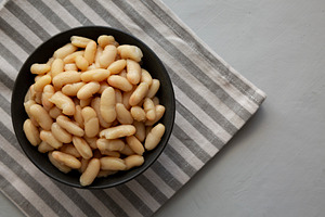 Organic Cannellini Beans in a Bowl, top view. Space for text., a Food & Drink Photo by LiudmylaChuhunova