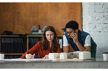 Young couple working as architects, a Business Photo by HalfPoint