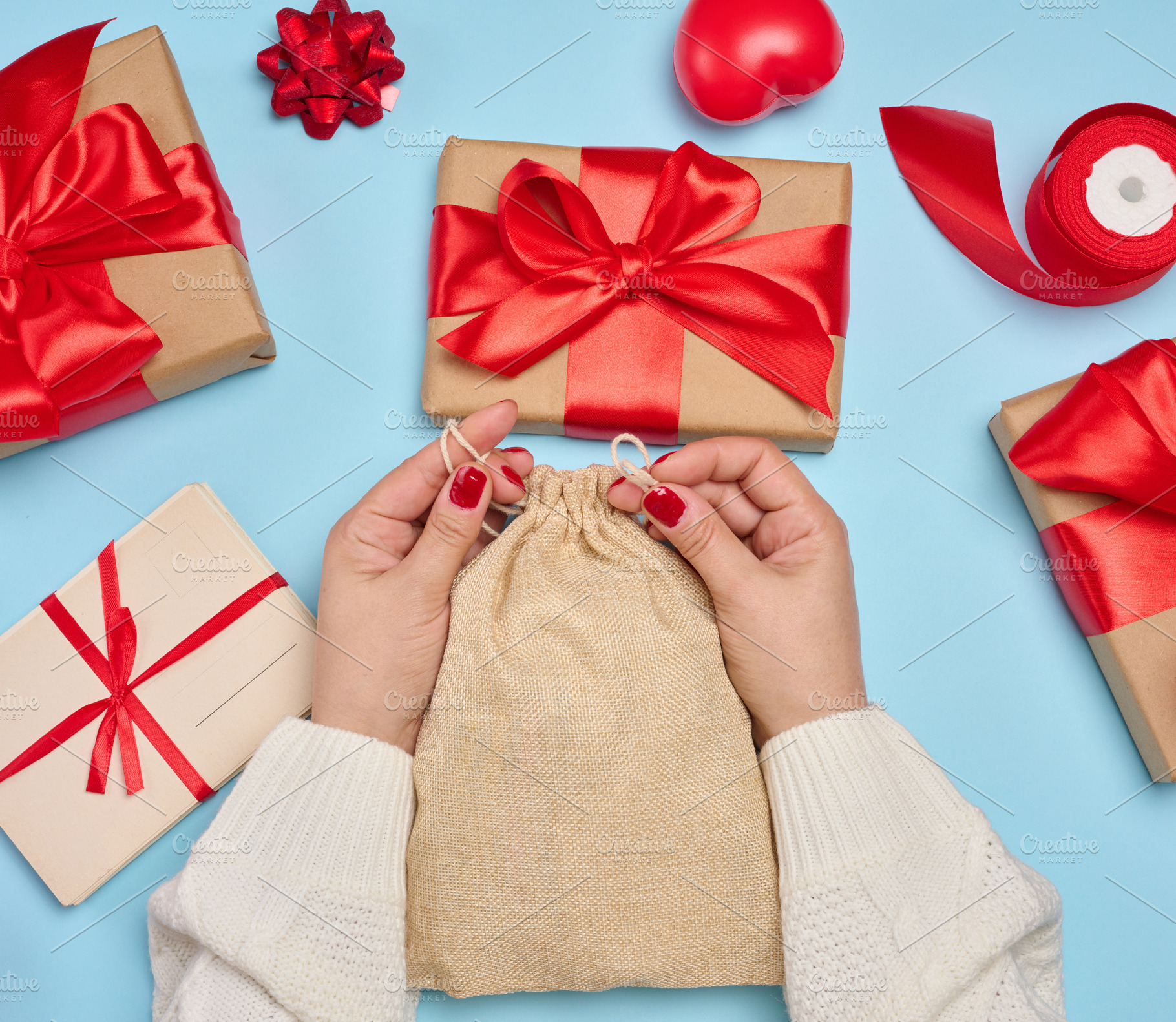 Female hands in a white sweater tightening a jute bag surrounded, a Holiday Photo by ndanko