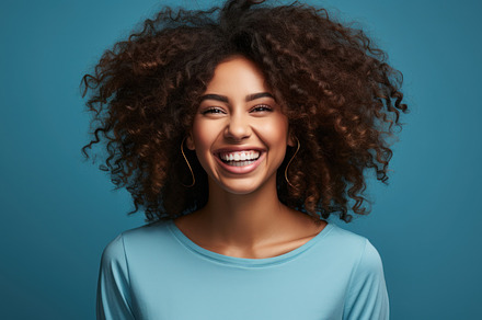 Beautiful african american woman with curly hair on blue backgro, a Beauty & Fashion Photo by AS photostudio
