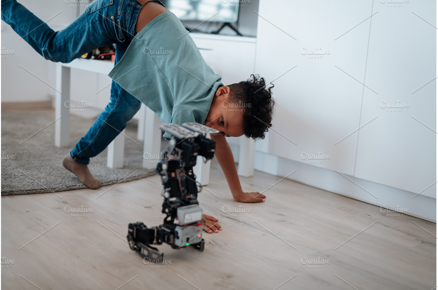 Boy having fun with small robot at, a School & Education Photo by HalfPoint