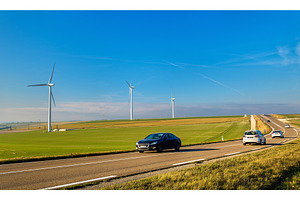 Cars on a highway and wind turbines in the background - France, a Transportation Photo by Leonid Andronov