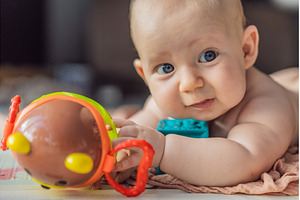 Little baby playing with toys on a, a Person Photo by Elizaveta Galitskaya