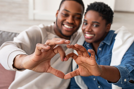 Portrait of african american couple making heart shape with hands, a Photo by Prostock-Studio