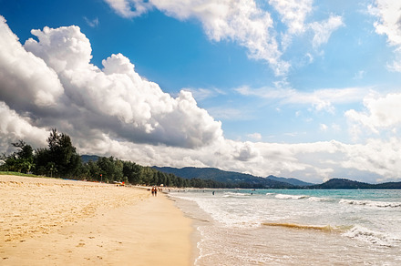 Tropical beach scenery at Andaman sea in Phuket, Thailand. Exotic sea view with people relaxing on vacation at tropical summer paradise beach of Phuket island with sunny sky and clouds on horizon, a Nature Photo by ifnotelse