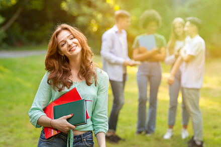Cute student girl with workbooks pos, a Photo by Prostock-Studio