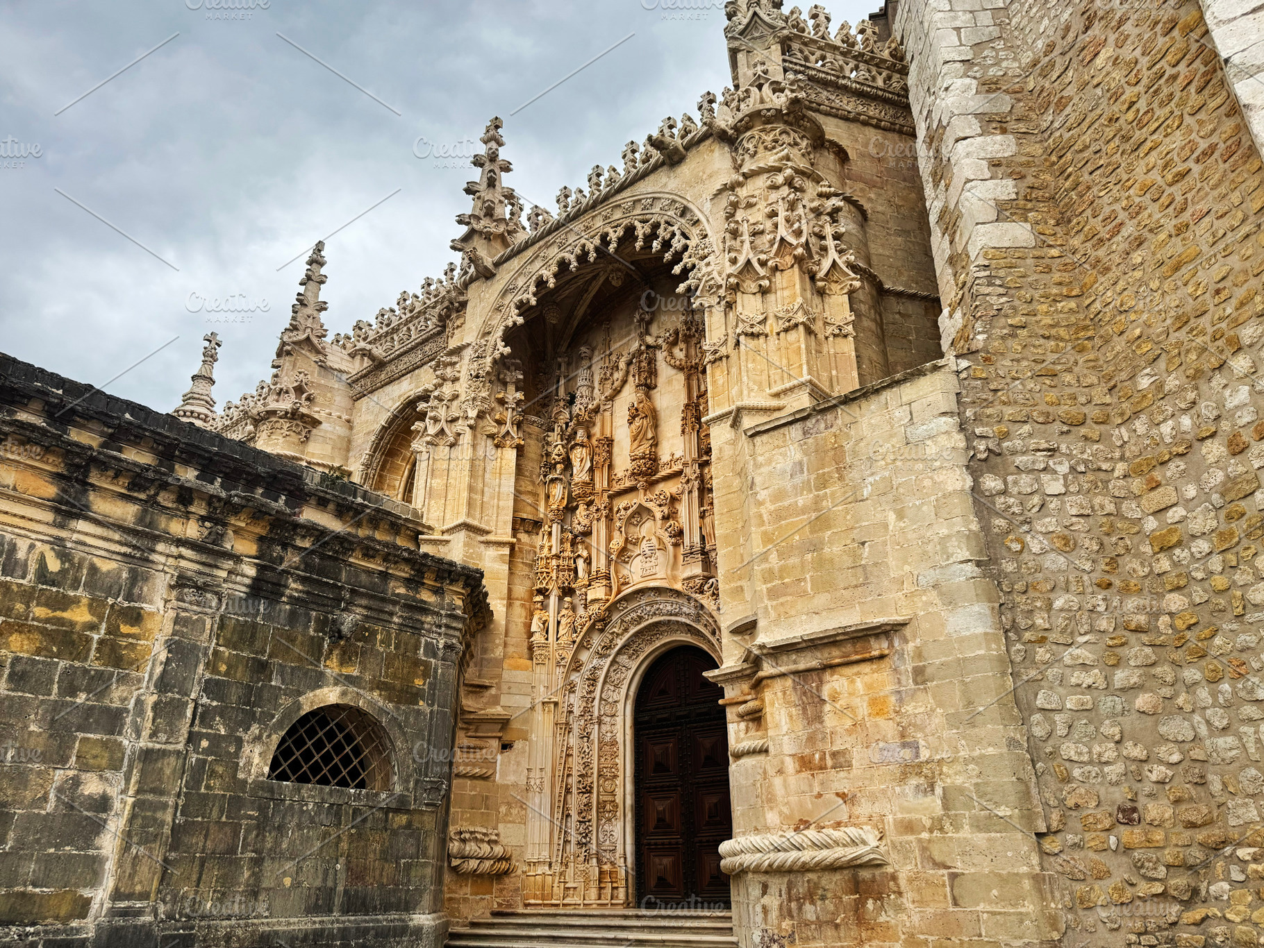 Ornate Gothic-style entrance at the Tomar Castle in Portugal with detailed carv, a Photo by AS photostudio