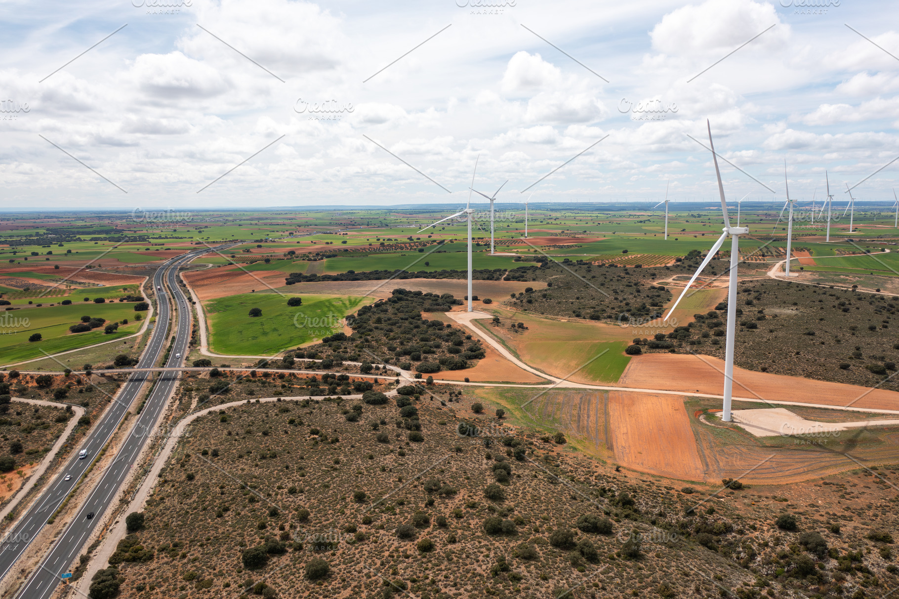 Aerial drone view of wind turbines on open fields next to highway, a Photo by andreonegin market