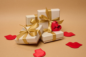 A stack of cream-colored gift boxes tied with gold satin ribbons, a Holiday Photo by ndanko