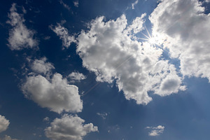 blue sky with clouds in bright weather, sky with clouds illuminated by sun, a Photo by rsoollAI