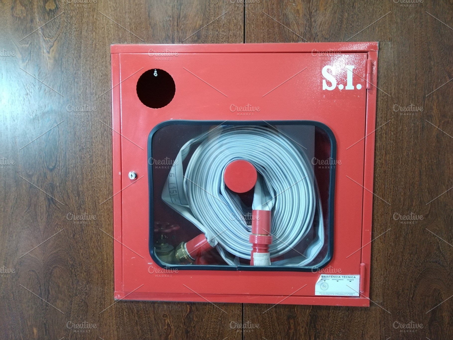 Red fire hose cabinet on wall, an Industrial Photo by DanFLCreativo