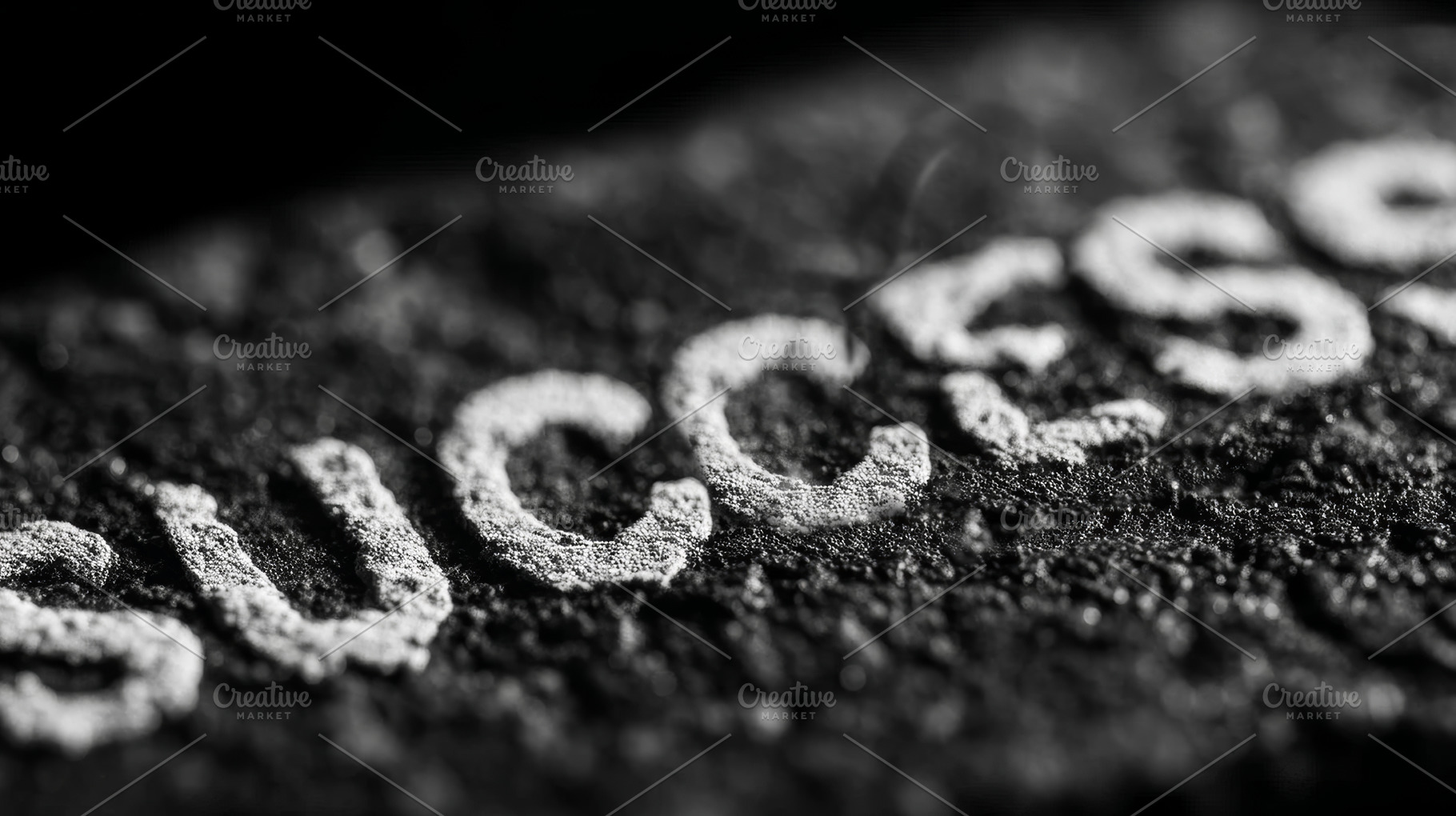 Close-up of success text on textured surface in black and white lighting, a Photo by AS photostudio