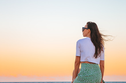 Happy woman enjoying beautiful sunset on the beach, a Person Photo by travnikovstudio