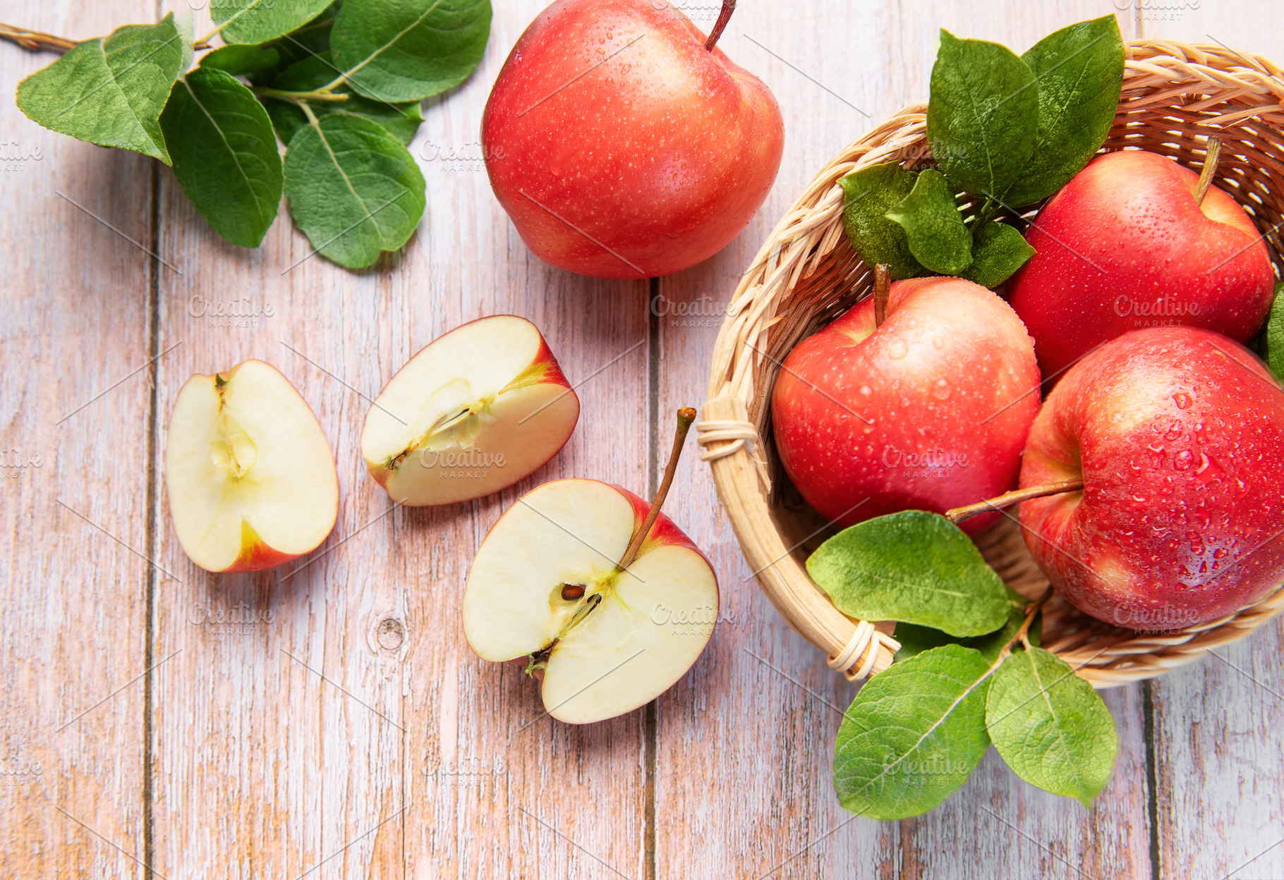 Fresh red apples in basket and sliced on wood, a Food & Drink Photo by Olena Rudo