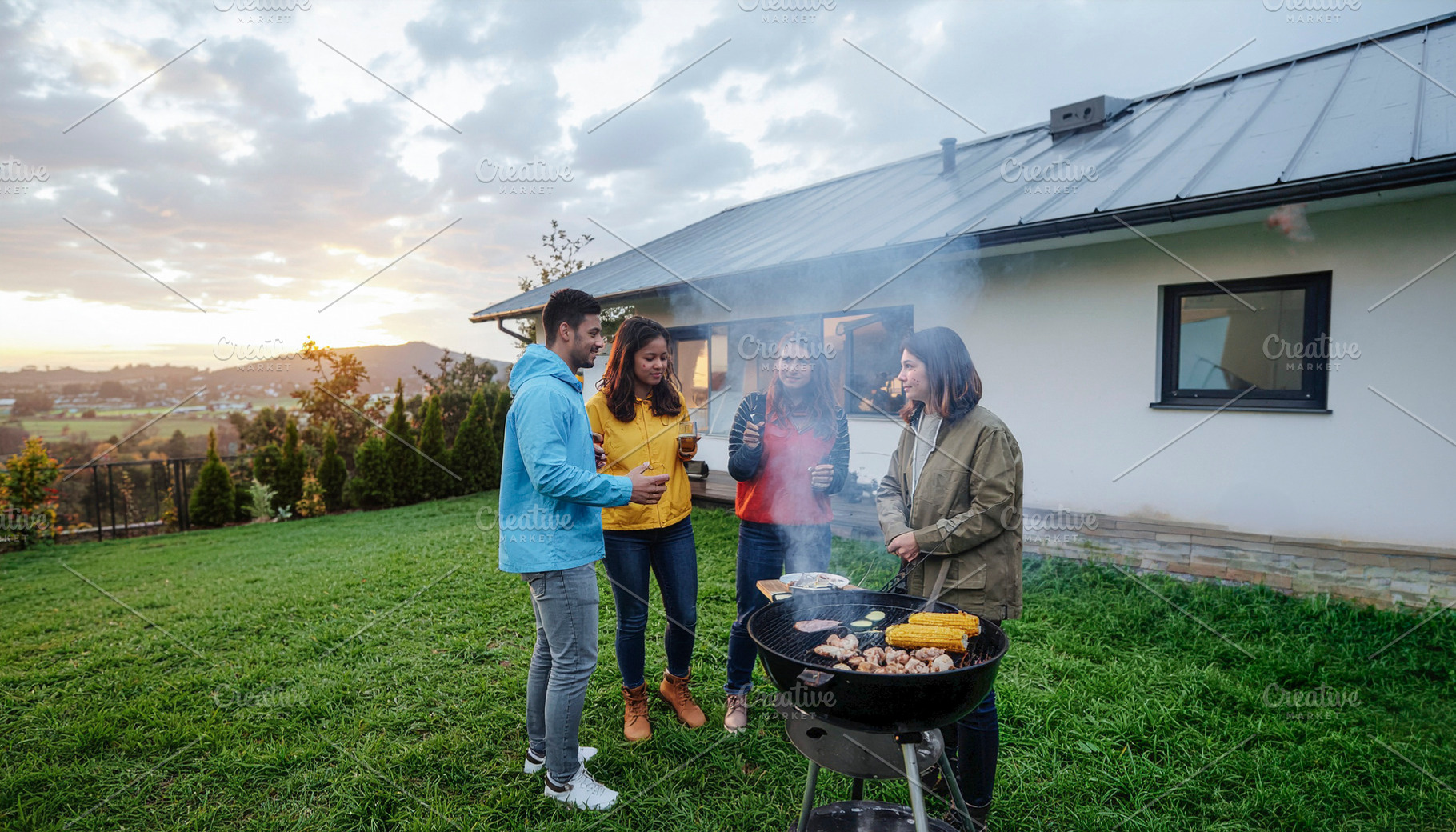 Group of friends grilling outdoors in stormy day, a Person Photo by DanFLCreativo