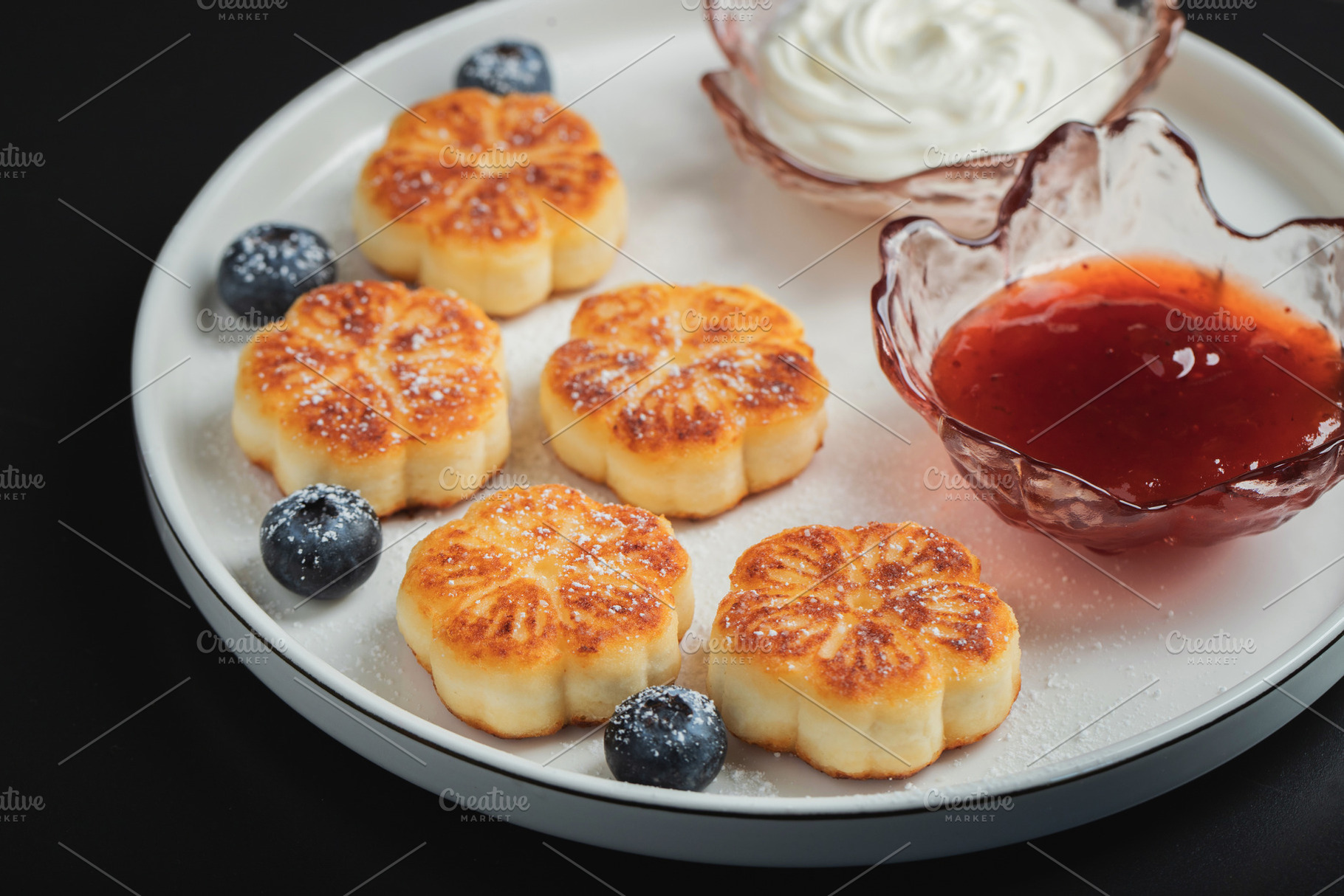 Cottage cheese pancakes, syrniki, curd fritters decorated with strawberry and r, a Food & Drink Photo by Budarinphoto