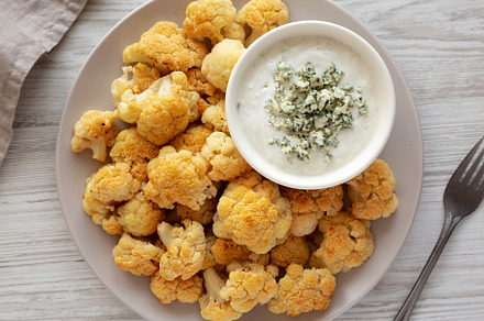 Homemade Buffalo Cauliflower with Blue Cheese Sauce, top view., a Food & Drink Photo by LiudmylaChuhunova