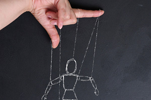 Conceptual image of manipulation, a human hand holding strings l, a Person Photo by ndanko