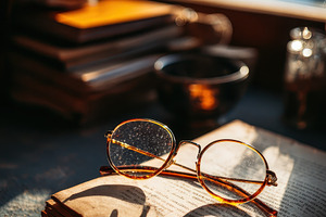 Vintage Glasses Resting on Open Book, a Photo by Pixeness Studio