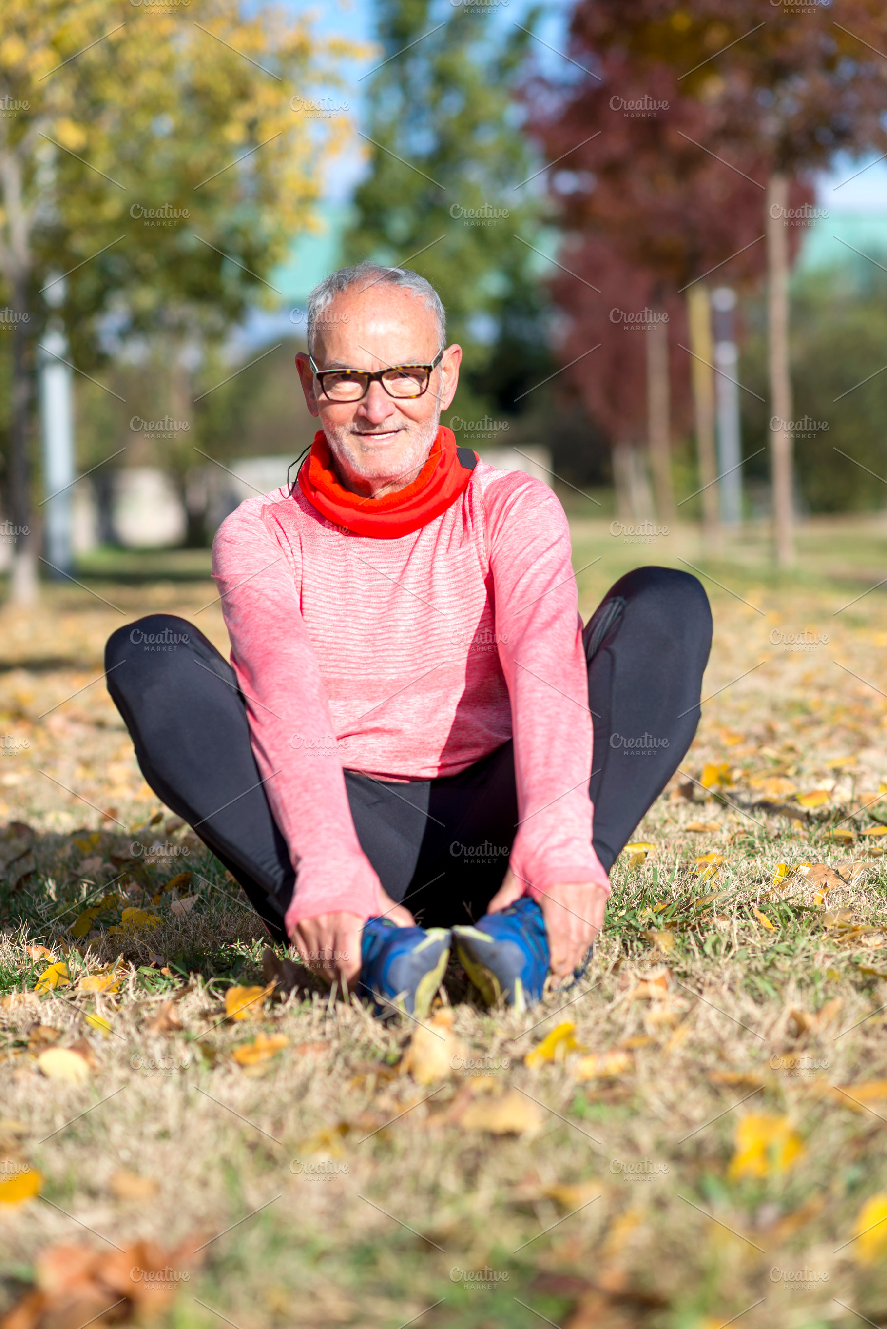 Senior man stretching on the grass during outdoor exercise, a Sports & Recreation Photo by RF Images