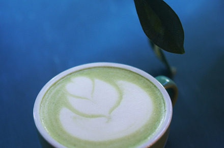 A cup of green matcha latte tea on the table, latte art, a Food & Drink Photo by PavelKant