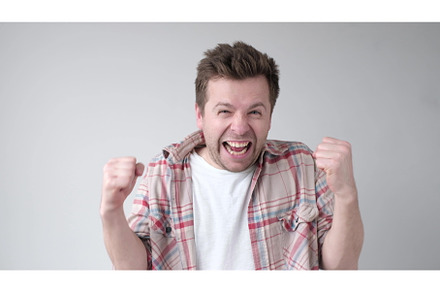 young caucasian man raising clenched, a Person Photo by Koldunova