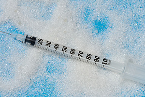 An insulin syringe with an open needle lies on scattered white s, a Health & Medical Photo by ndanko