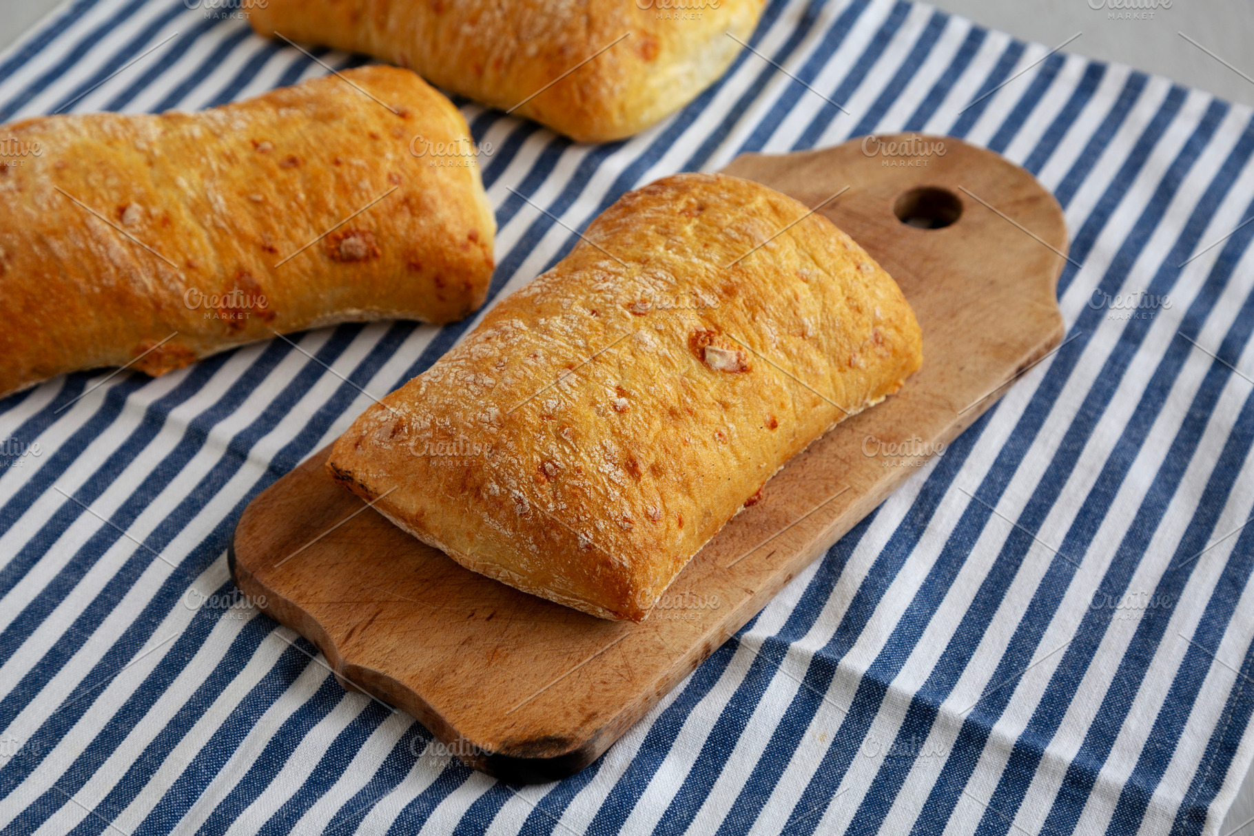 Homemade Cheese Ciabatta Bread on a Wooden Board, side view., a Food & Drink Photo by LiudmylaChuhunova