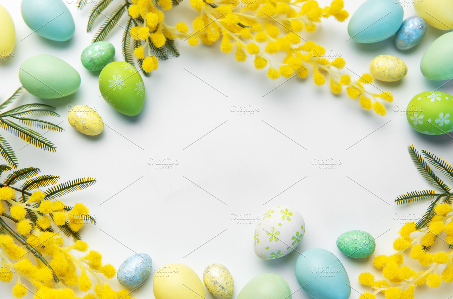 Easter eggs and mimosa forming a festive frame, a Holiday Photo by Olena Rudo