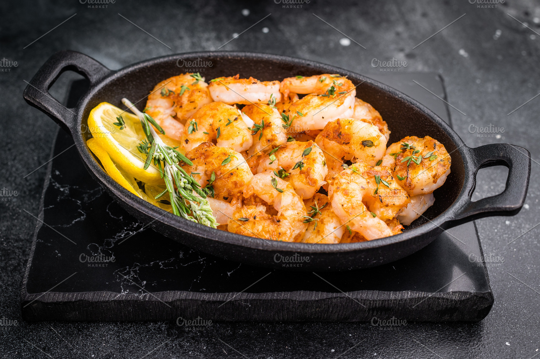 Grilled shrimps prawns in a cast iron skillet on a black slate s, a Food & Drink Photo by composter-box@mail.ru