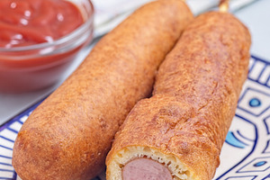 Corn dogs on white blue plate, served with ketchup, vertical closeup, a Food & Drink Photo by iuliia_n