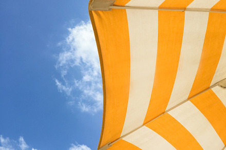 Yellow umbrella on the beach, an Abstract Photo by KYNA STUDIO