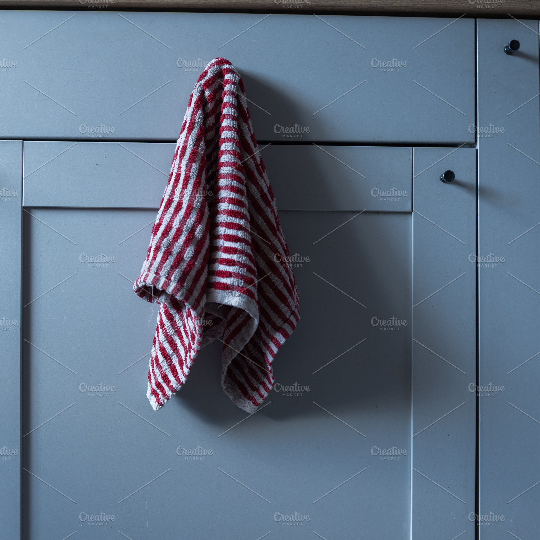 Kitchen cabinet door with a red and white striped towel hanging, an Industrial Photo by MDBildes
