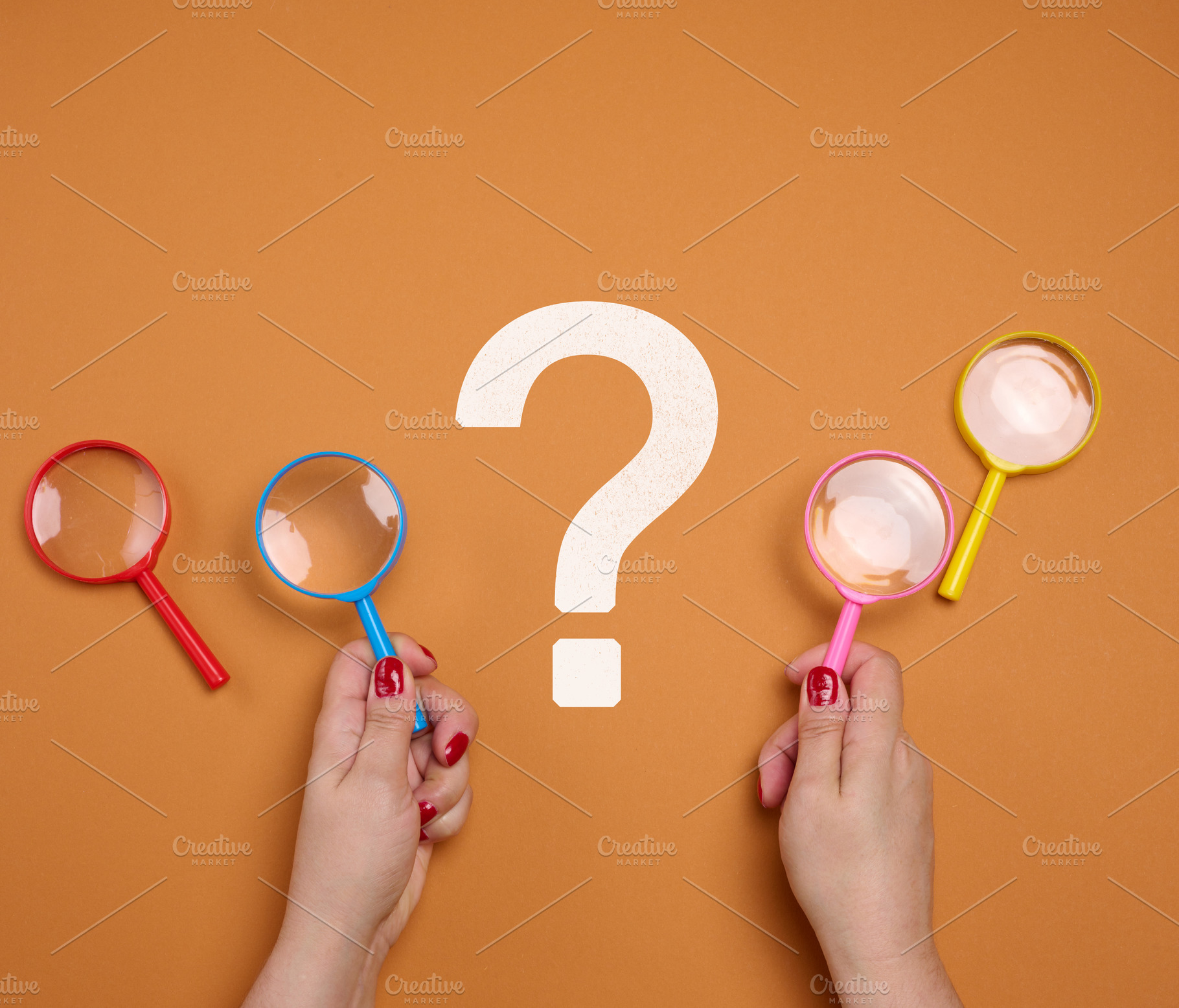 Female hands holding a plastic magnifying glass and a question m, a Business Photo by ndanko